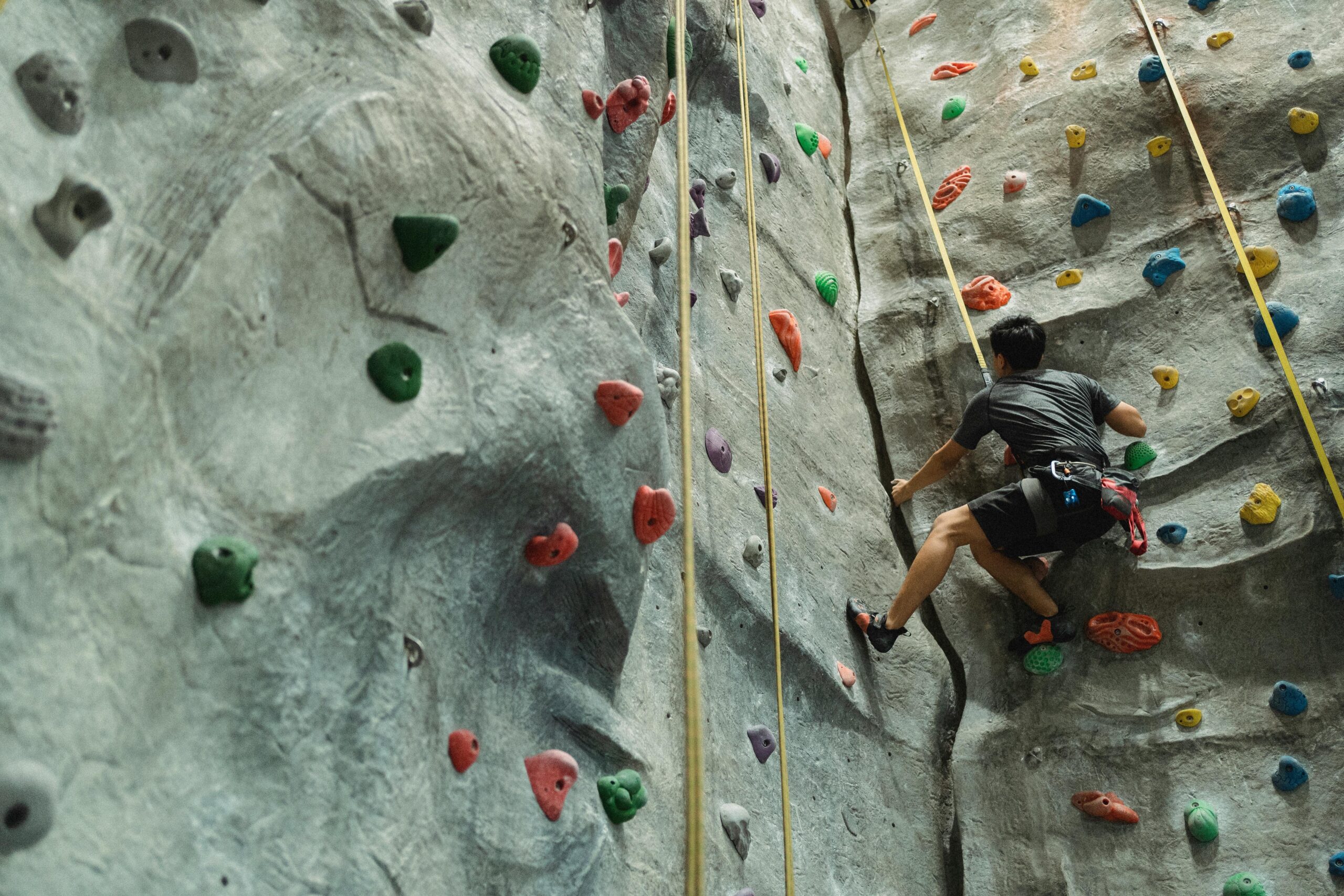 A climber struggling with a tangled rope during an ascent
