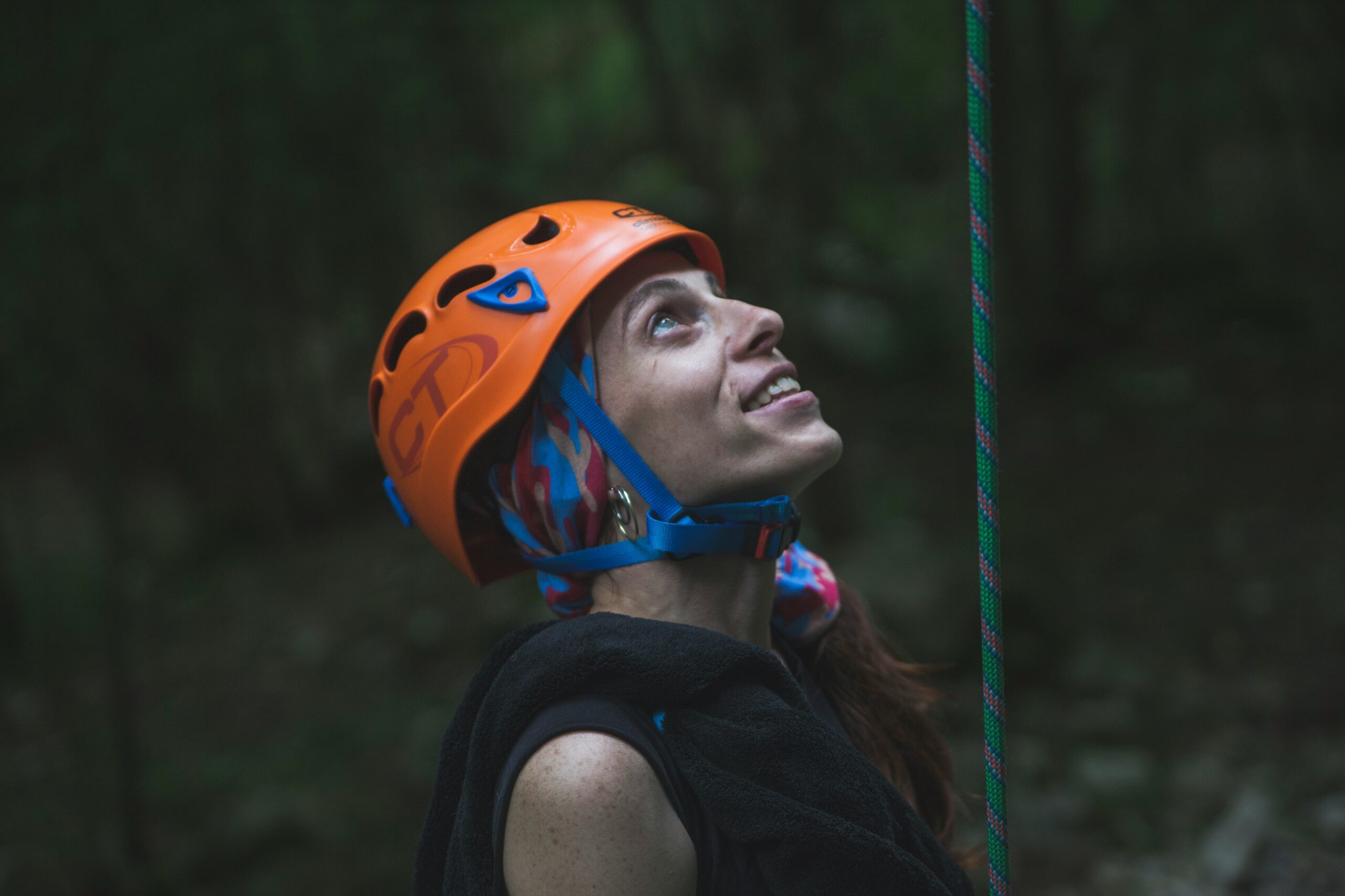 Photo of Jamie smiling confidently beside their climbing safety harness