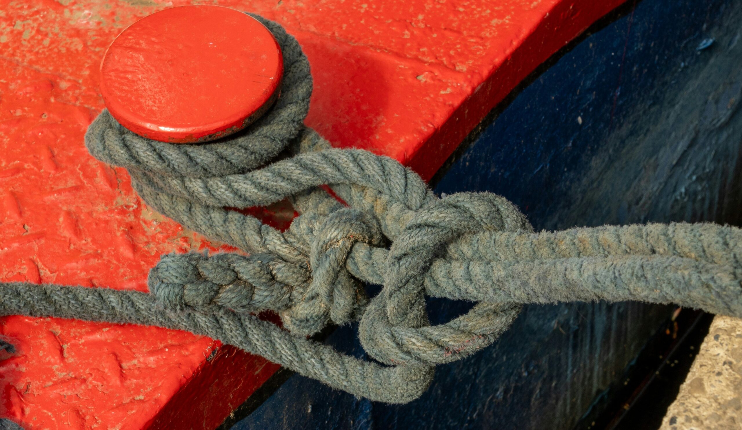 Worn-out climbing rope showing signs of abrasion near an edge