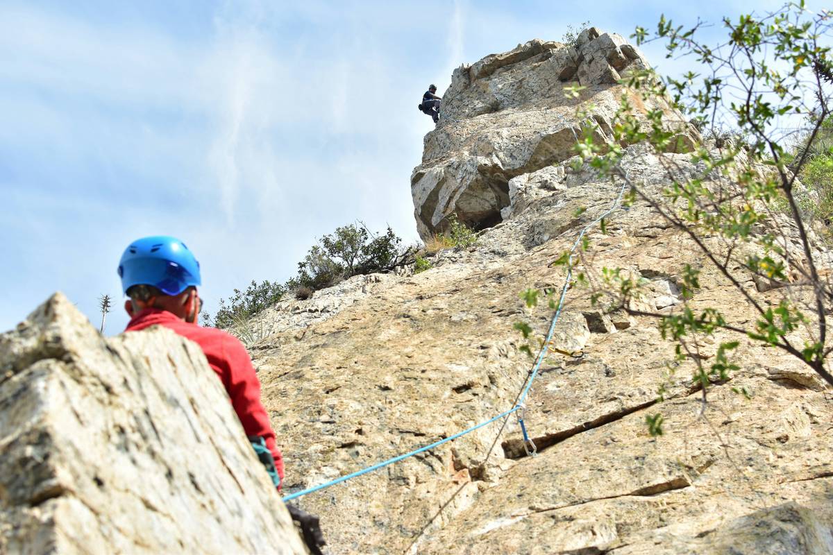 Detailed close-up shot showing correct threading of a rope through an ATC belay device