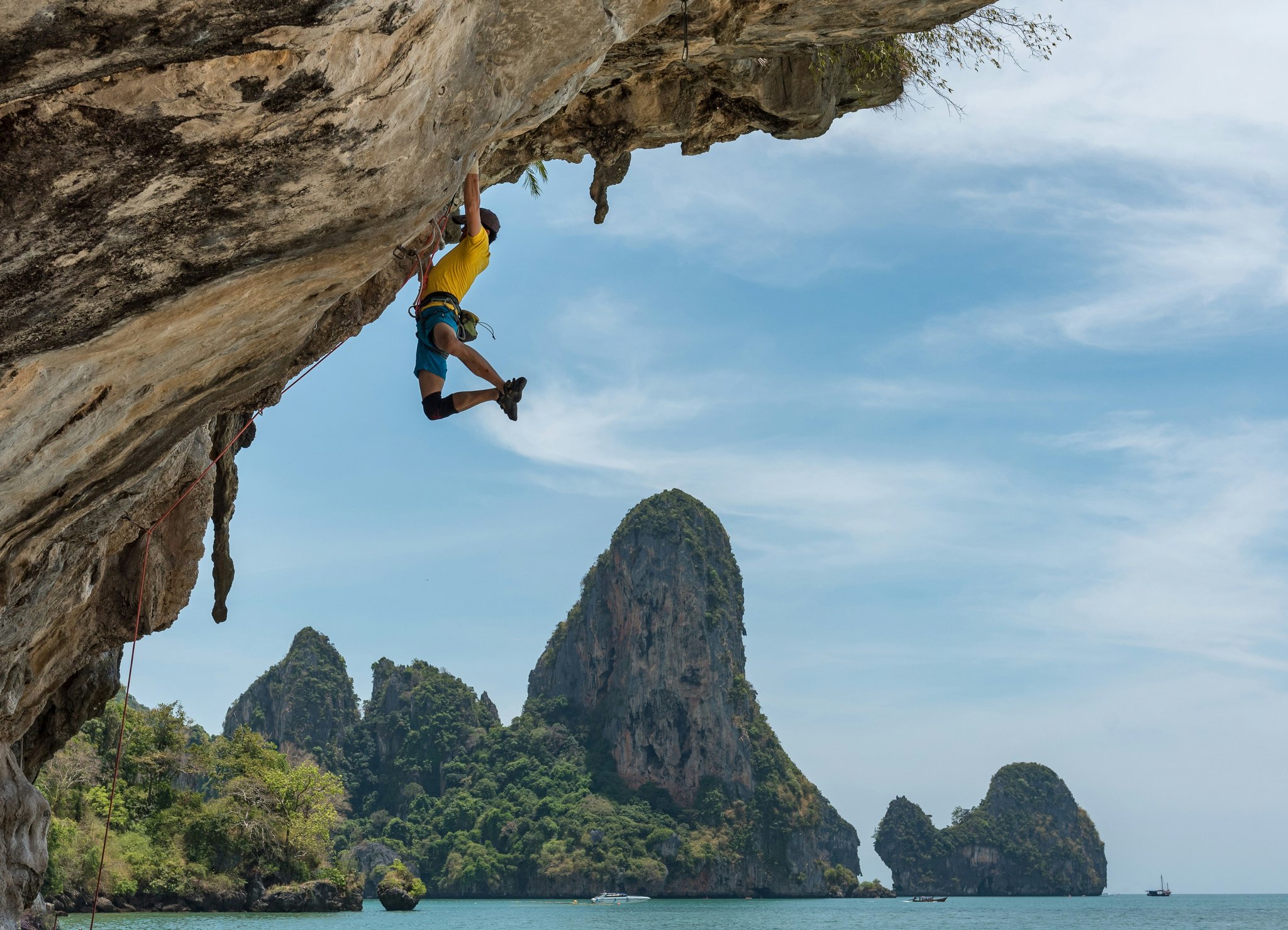 Smiling climber celebrating after successful ascent with proper rope handling